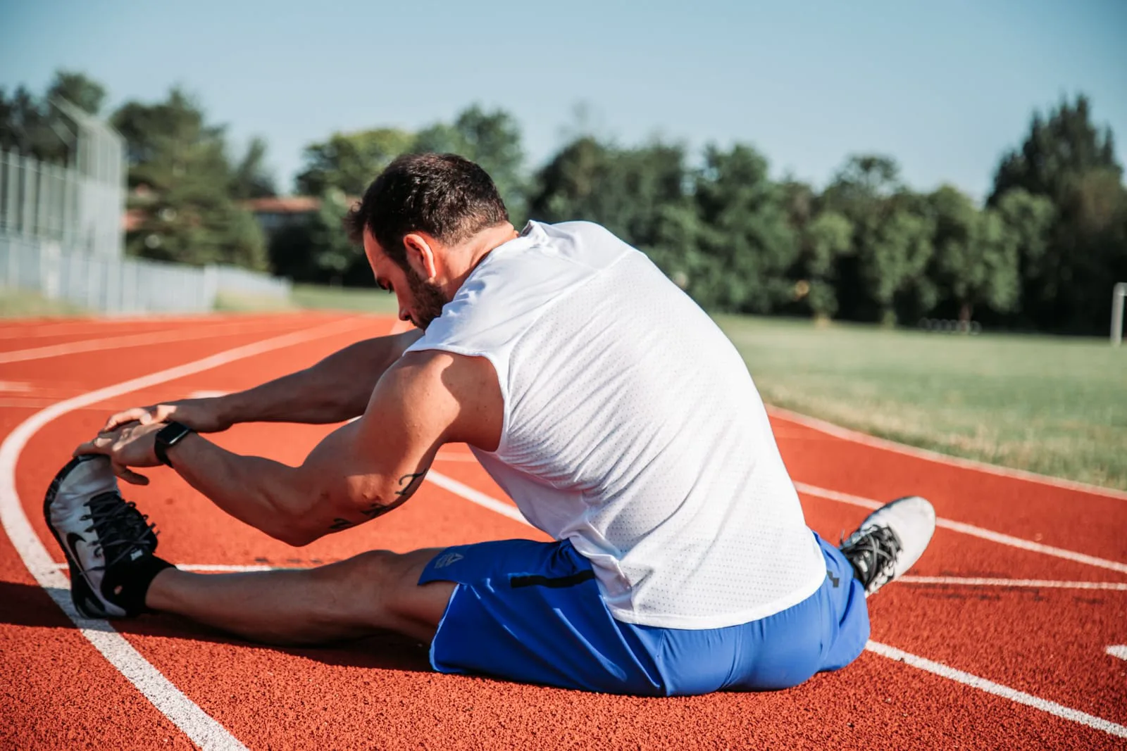 Runner in allungamento su una pista di atletica
